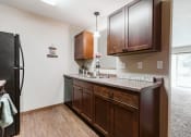 Thumbnail 4 of 17 - Grand Forks, ND Grandview II Apartments. A kitchen with black appliances.