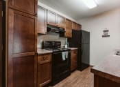 Thumbnail 3 of 17 - Grand Forks, ND Grandview II Apartments. A kitchen with black appliances.