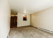 Thumbnail 2 of 17 - Grand Forks, ND Grandview II Apartments. A living room with baseboard heaters and a dining room in the background