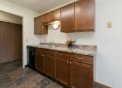 Thumbnail 19 of 34 - a kitchen with wooden cabinets and granite counter tops
