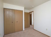 Thumbnail 11 of 14 - a bedroom with two closets and a door to a hallway. Fargo, ND Hazelwood Townhomes