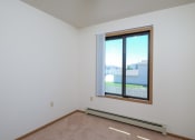 Thumbnail 10 of 14 - an empty room with a window and a carpet. Fargo, ND Hazelwood Townhomes