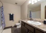 Thumbnail 8 of 10 - a bathroom with a sink and a toilet and a mirror. Bismarck, ND Highland Meadows Apartments