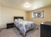 Thumbnail 5 of 10 - a bedroom with a bed and a window. Bismarck, ND Highland Meadows Apartments