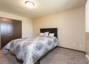 Thumbnail 6 of 10 - a bedroom with a bed and a wardrobe and a window. Bismarck, ND Highland Meadows Apartments