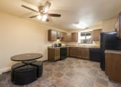 Thumbnail 2 of 10 - an empty kitchen with a ceiling fan and a table. Bismarck, ND Highland Meadows Apartments