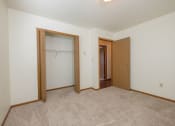 Thumbnail 8 of 9 - a  bedroom with an open closet.  Fargo, ND Hunters Run Apartments