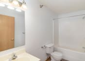 Thumbnail 20 of 23 - a bathroom with a toilet and a tub and a sink. Hutchinson, MN Deer Park Apartments