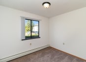 Thumbnail 18 of 23 - an empty room with a window and a carpet. Hutchinson, MN Deer Park Apartments