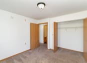 Thumbnail 17 of 23 - an empty bedroom with a closet and a door to a bathroom. Hutchinson, MN Deer Park Apartments