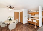 Thumbnail 2 of 23 - a dining room with a table and chairs and a kitchen. Hutchinson, MN Deer Park Apartments