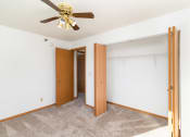 Thumbnail 12 of 23 - an empty bedroom with a ceiling fan and a closet. Hutchinson, MN Deer Park Apartments