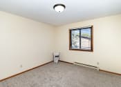 Thumbnail 8 of 11 - an empty room with carpet and a window. Hutchinson, MN Echo Manor Apartments