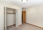 Thumbnail 9 of 11 - a bedroom with a closet and an open door. Hutchinson, MN Echo Manor Apartments