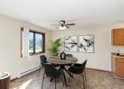 Thumbnail 2 of 11 - a dining room with a table and chairs and a ceiling fan. Hutchinson, MN Echo Manor Apartments