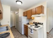 Thumbnail 7 of 11 - a kitchen with white appliances and wooden cabinets and a white refrigerator. Hutchinson, MN Echo Manor Apartments