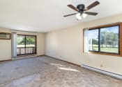 Thumbnail 5 of 11 - an empty living room with a ceiling fan and a window. Hutchinson, MN Echo Manor Apartments