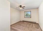 Thumbnail 10 of 18 - a bedroom with carpet and a ceiling fan. Hutchinson, MN Twin Oaks Townhomes