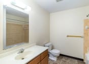 Thumbnail 17 of 18 - a bathroom with a toilet and a sink and a mirror. Hutchinson, MN Twin Oaks