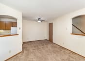 Thumbnail 9 of 18 - an empty living room with a ceiling fan and a door to a kitchen. Hutchinson, MN Twin Oaks Townhomes