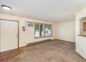 Thumbnail 7 of 18 - an empty living room with a white door and a window. Hutchinson, MN Twin Oaks Townhomes