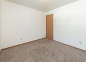 Thumbnail 10 of 13 - a bedroom with white walls and carpet. Fargo, ND White Ridge Apartments