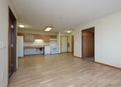 Thumbnail 3 of 21 - a kitchen and living room with wood floors. Fargo, ND Crossroads Apartments