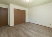 Thumbnail 23 of 34 - a bedroom with carpet and a door to a closet. Fargo, ND Islander Apartments