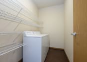 Thumbnail 16 of 23 - a laundry room with a washer and dryer and a door to a closet. Fargo, ND North Sky Apartments