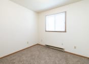 Thumbnail 9 of 13 - a bedroom with white walls and a window. Fargo, ND White Ridge Apartments