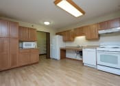 Thumbnail 4 of 21 - a kitchen with white appliances and wooden cabinets. Fargo, ND Crossroads Apartments