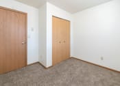 Thumbnail 8 of 13 - a bedroom with a closet door. Fargo, ND White Ridge Apartments
