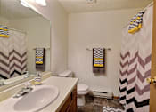 Thumbnail 12 of 20 - a bathroom with a sink and a shower and a toilet. Fargo, ND Kennedy Apartments
