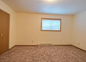 Thumbnail 8 of 20 - an empty room with a door and a window. Fargo, ND Kennedy Apartments