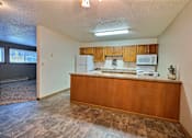 Thumbnail 7 of 20 - an empty kitchen with wood cabinets and a counter top. Fargo, ND Kennedy Apartments