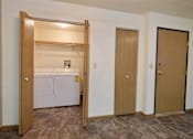 Thumbnail 10 of 20 - a laundry room with a washer and dryer and a door. Fargo, ND Kennedy Apartments