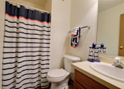 Thumbnail 11 of 20 - a bathroom with a shower and a sink and a toilet. Fargo, ND Kennedy Apartments