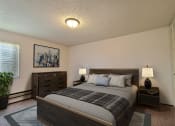 Thumbnail 3 of 18 - Fargo, ND Kingswood Apartments. a bedroom with a bed with night stands and a dresser.