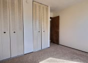 Thumbnail 16 of 18 - a room with two closets and a door to a hallway. Fargo, ND Kingswood Apartments | Bedroom