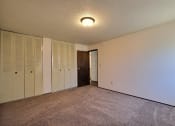 Thumbnail 10 of 18 - a bedroom with white walls and a door to a closet. Fargo, ND Kingswood Apartments