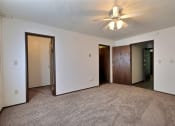 Thumbnail 8 of 18 - a bedroom with a ceiling fan and a closet. Fargo, ND Kingswood Apartments