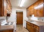 Thumbnail 18 of 25 - a kitchen with a stove and sink and a refrigerator. Fargo, ND Betty Ann Apartments