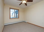 Thumbnail 7 of 21 - a bedroom with a window and a carpeted floor. Fargo, ND Crossroads Apartments