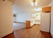 Thumbnail 27 of 49 - Akitchen and living room with wood flooring and white walls. Fargo, ND Lake Crest Apartments.
