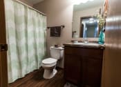 Thumbnail 17 of 20 - Grand Forks, ND Library Lane Apartments a bathroom with a toilet sink and shower