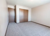 Thumbnail 15 of 20 - Grand Forks, ND Library Lane Apartments an empty bedroom with a closet and a carpeted floor