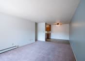 Thumbnail 15 of 25 - the living room and dining room of an apartment with carpet and white walls. Fargo, ND Betty Ann Apartments