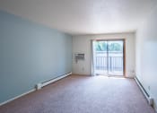 Thumbnail 14 of 25 - an empty living room with a door to a balcony. Fargo, ND Betty Ann Apartments