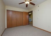 Thumbnail 8 of 21 - a bedroom with a closet and a door to a hallway. Fargo, ND Crossroads Apartments