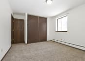 Thumbnail 24 of 32 - an empty room with white walls and a window and two closet doors. Maplewood, MN Maplewood Apartments